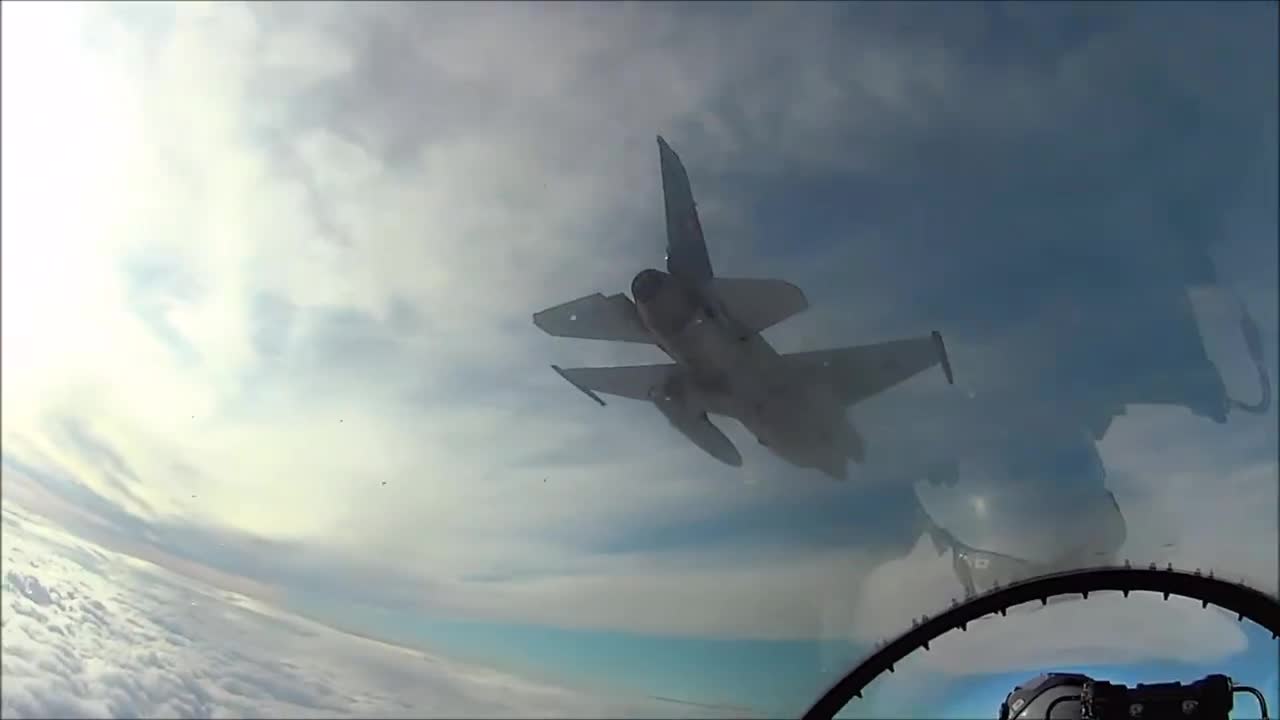 Cockpit view of F16 Fighting Falcon above a sea of clouds