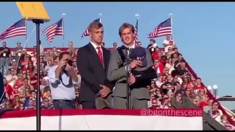 Two high school students in Miami are running into football game with waving flags...