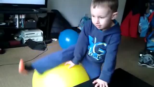 Boy sits pops yellow balloon cries