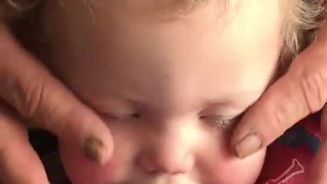 Grandpa gives baby relaxing face massage