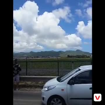Plane taking off from st marteen airport near a beach