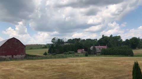 Peaceful Time Lapse Video of Cloudscape over a Farmstead and Pasture.