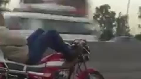 A man driving a motorcycle with his feet