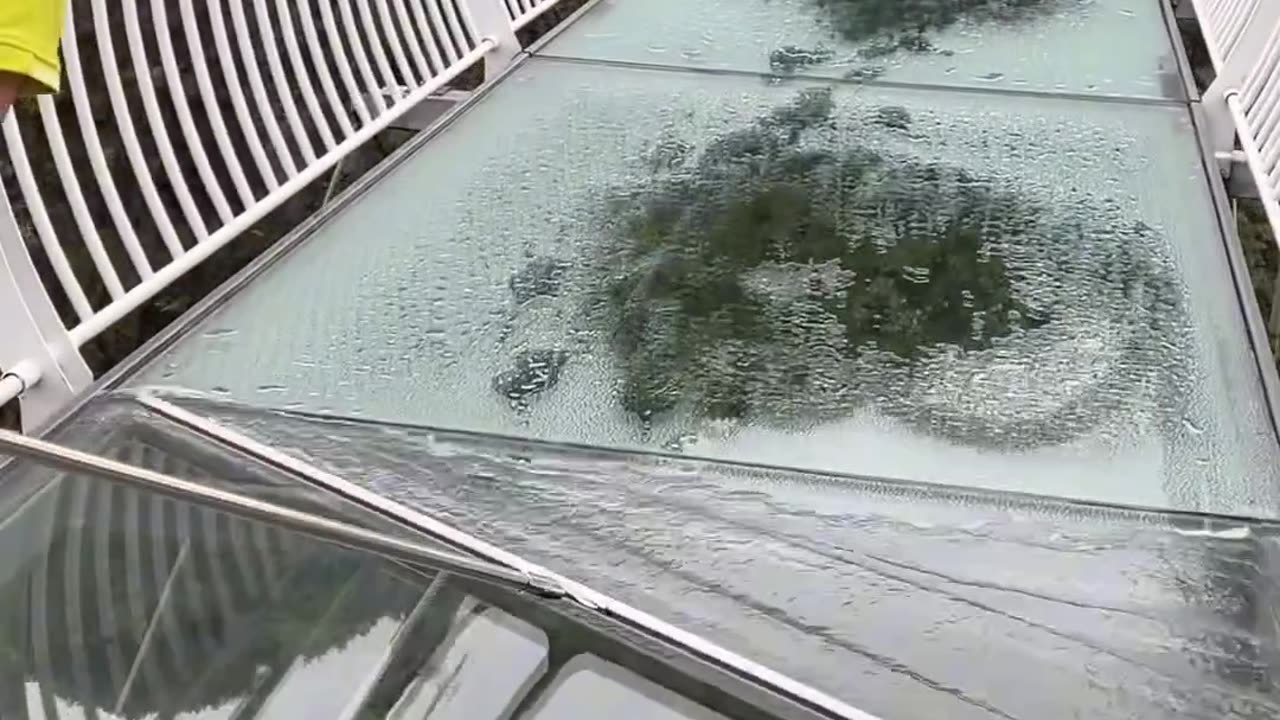 Experience the calming satisfaction of watching a transparent glass bridge being cleaned.