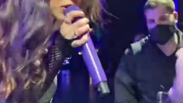 Olivia Rodrigo singing “Brutal” with a fan