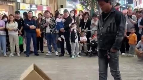 Mágica da pessoa entrando numa caixa de papelão na rua