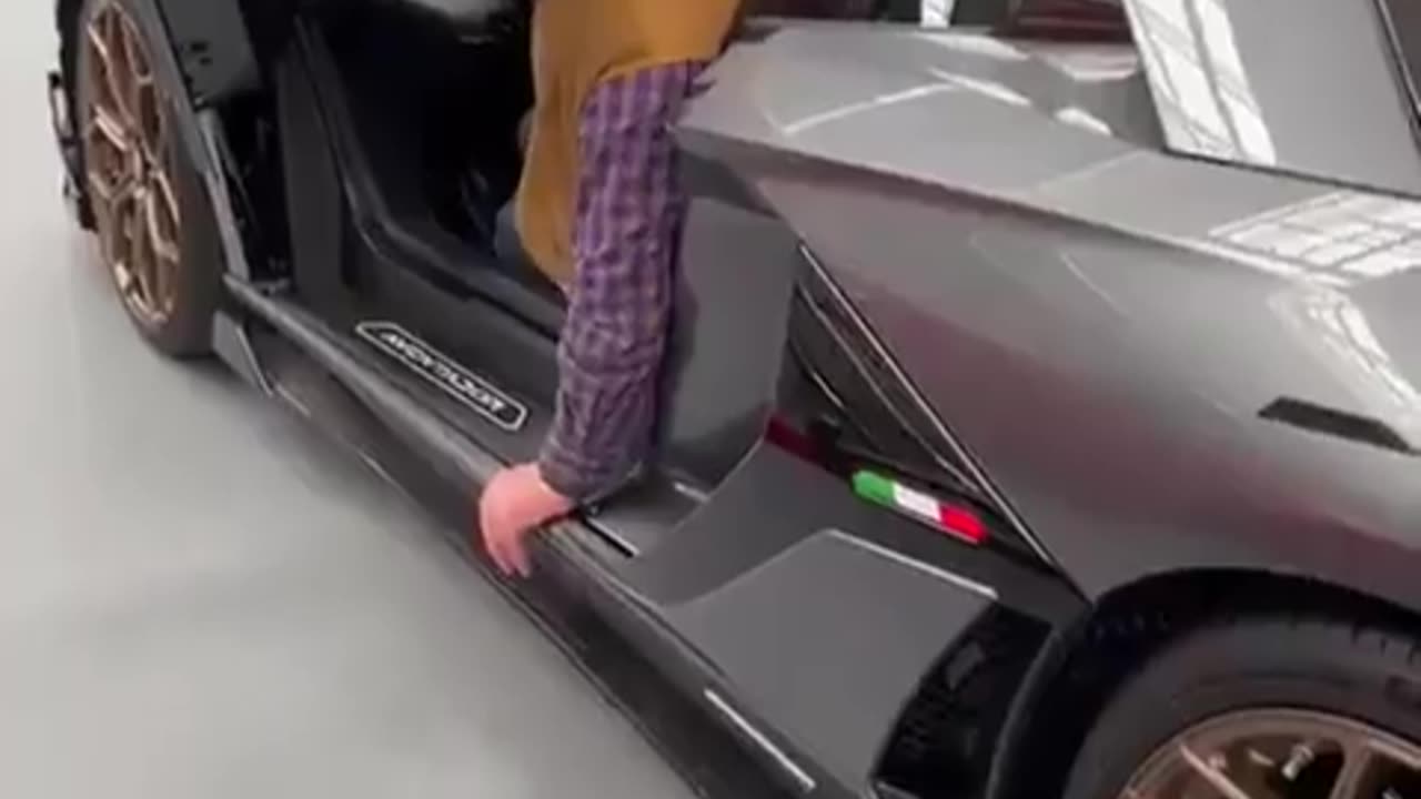 Elderly man struggles to get out of a Lambo.