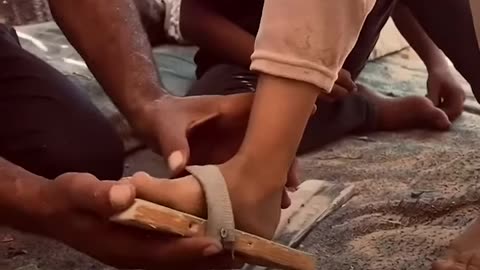 Displaced Palestinian in Gaza crafts slippers from wood and fabric