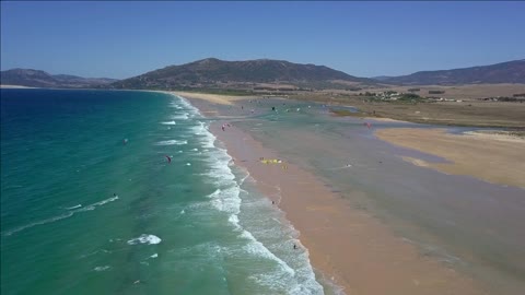 picturesque view of tropical sea shoreline with blue water washing sands and tourists spending time