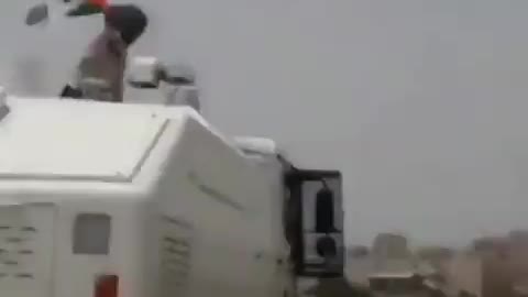 Palestinian woman climbs aboard Israeli armored vehicle and hoists Palestinian flag