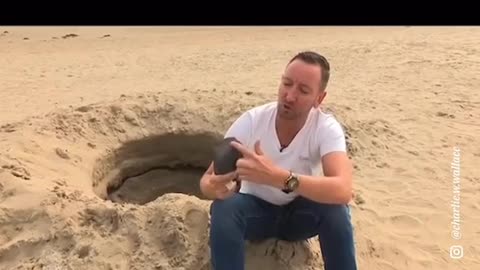 Man digging a mysterious hole inthe beach