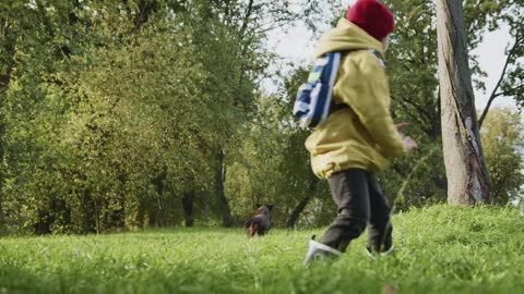 A Kid Playing with Her Dog while Sitting on the Grass #2