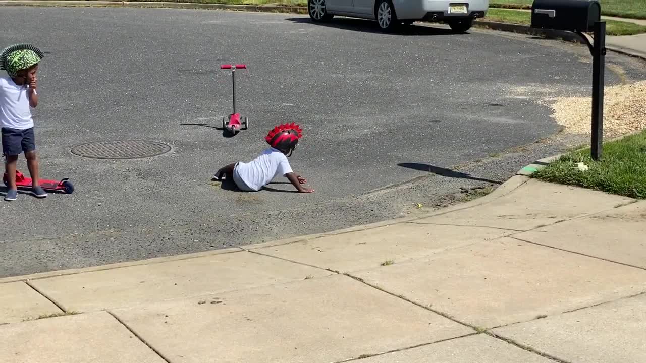 Toddler Falls Off His Scooter While Riding It Down The Driveway