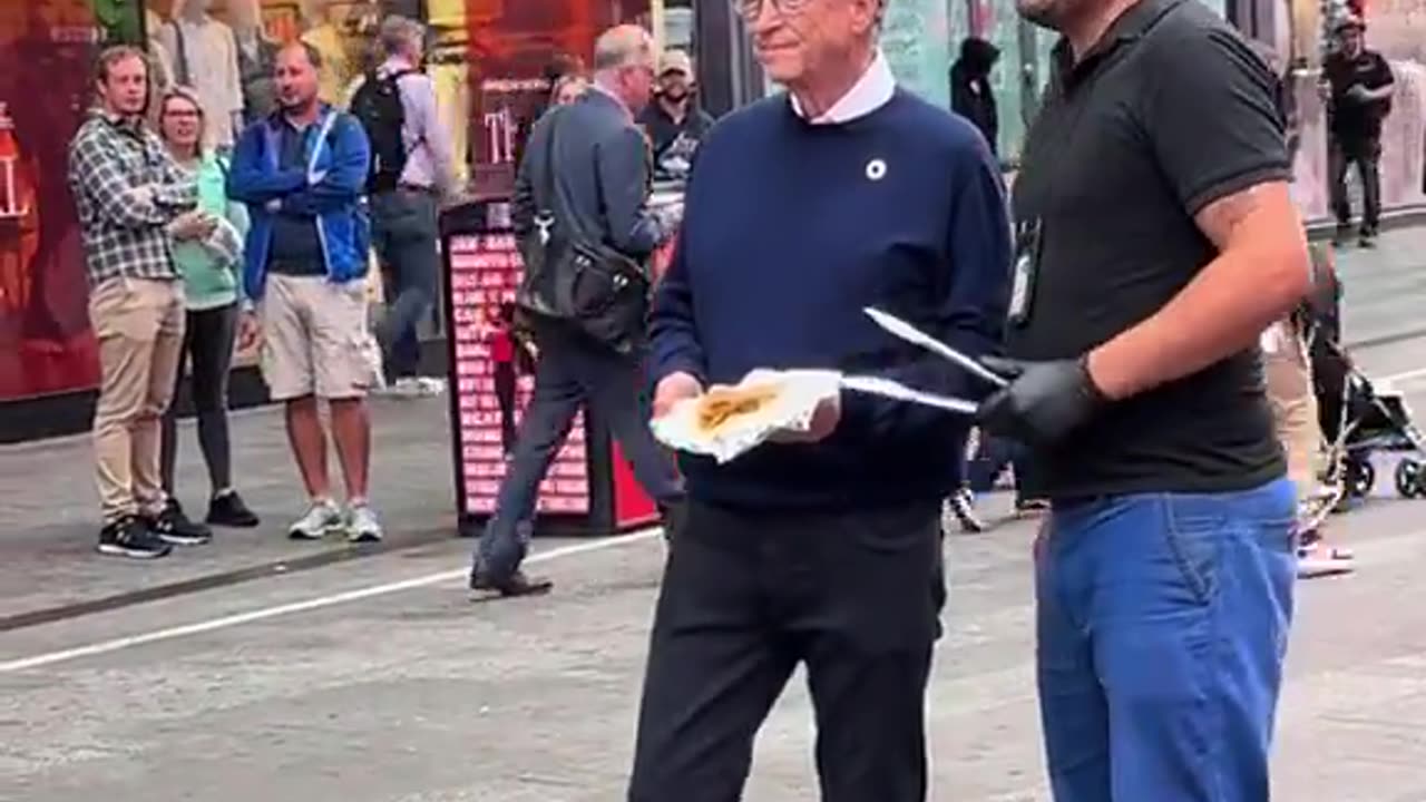 Bill Gates seen doing a photo shoot of himself eating a hot dog in Times Square.