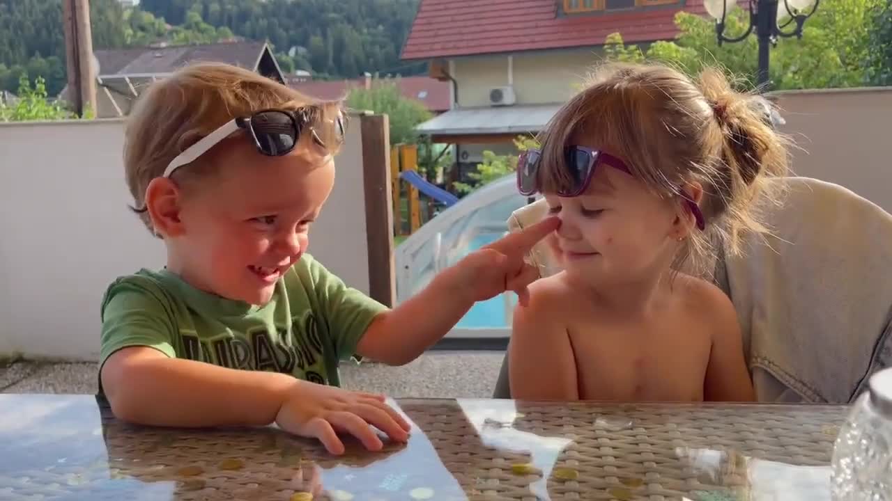 Sweet boy showers little girl with kisses