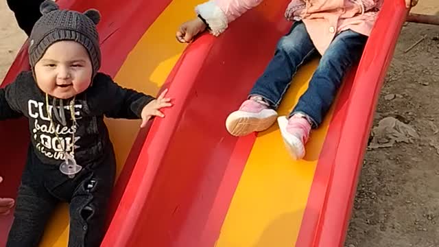 Cute babies sliding in park