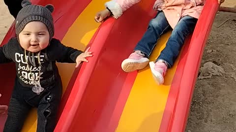 Cute babies sliding in park