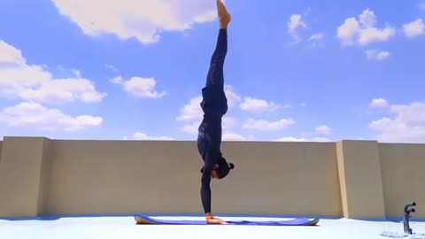 Guy Shows Yoga Postures in Handstand Position on Terrace