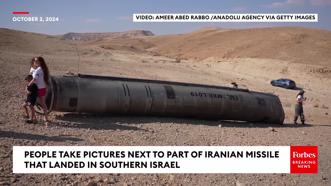 People Take Pictures Next To Remnants Of Iranian Missile That Landed In Southern Israel