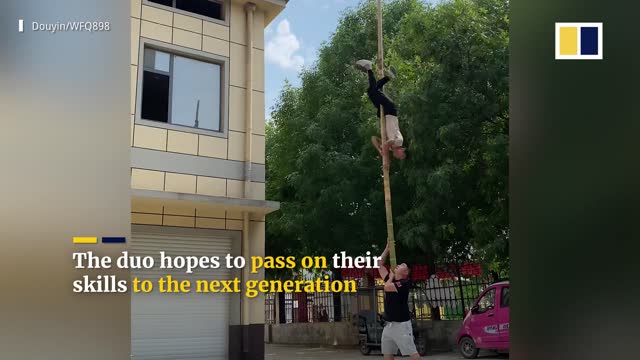 Acrobat performs extreme stunts on pole without harness