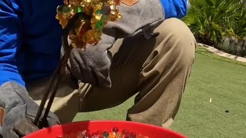 Pouring molten metal into water beads to make a sculpture