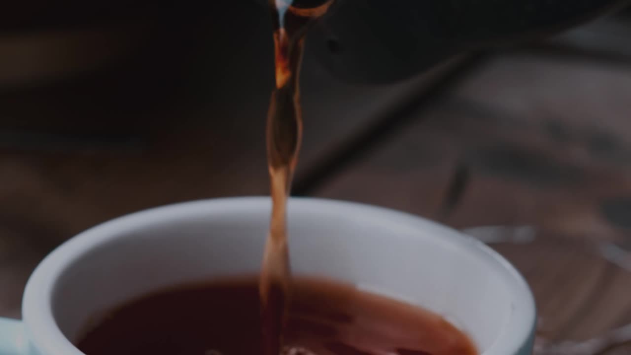 Pouring a cup of tea in a cafe
