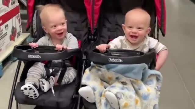 Twin Babies Seem to Enjoy as Adult Moves Them Back and Forth in Twin Stroller