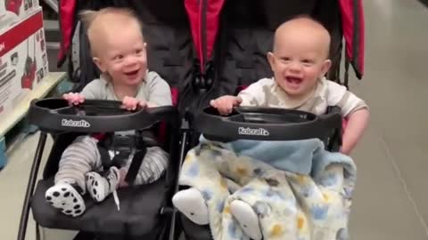 Twin Babies Seem to Enjoy as Adult Moves Them Back and Forth in Twin Stroller