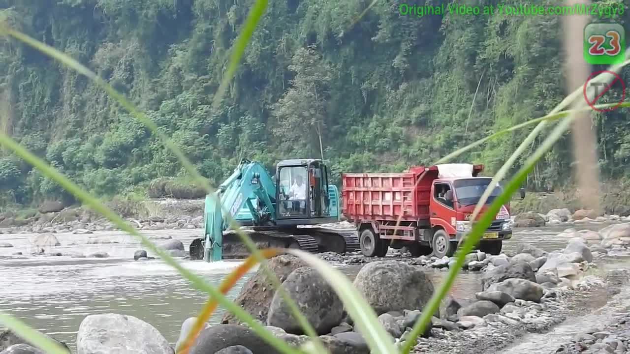 Excavator trucks digging san from the river.