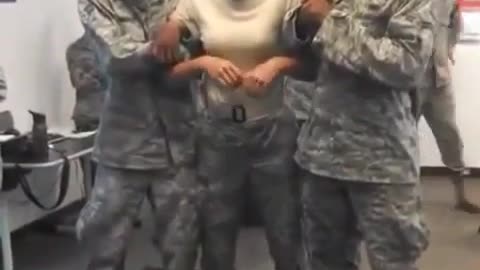 Two soldiers are holding up a female soldier while chatting