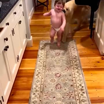 The child runs from his friend the dog while he is learning to walk and laughs 😍!
