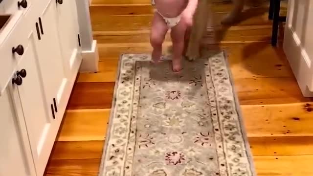 The child runs from his friend the dog while he is learning to walk and laughs 😍!