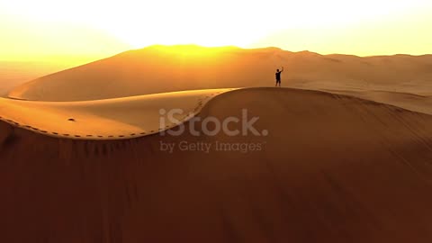 Ariel drone footage of solitary man in Namibian Desert