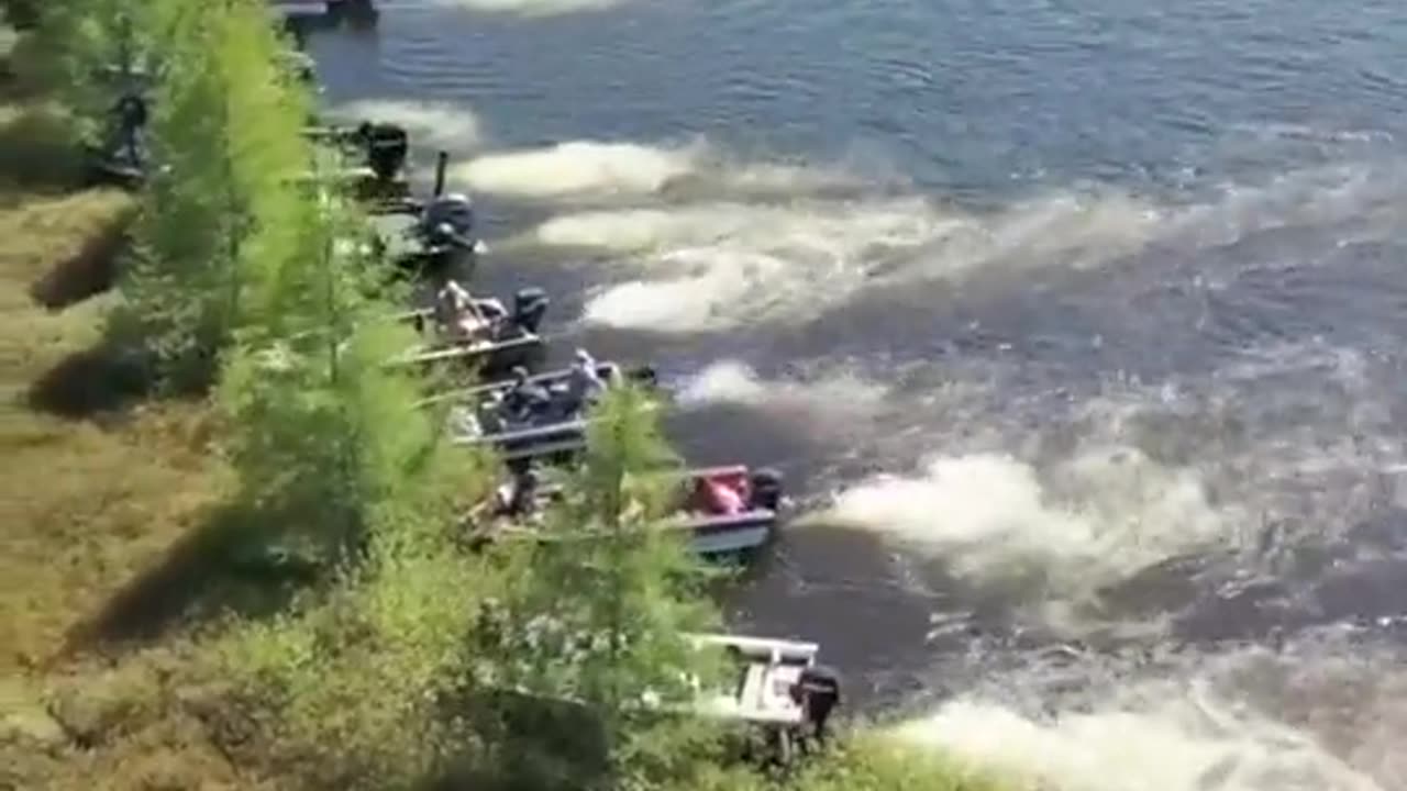 Boat owners moving a large floating island out of the way on Wisconsin's Lake