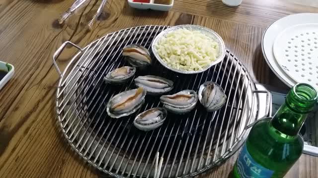 Abalones are being grilled with cheese.