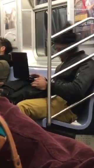 Beanie guy bangs head to laptop on subway