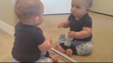 A baby with a mysterious self reflected in the mirror