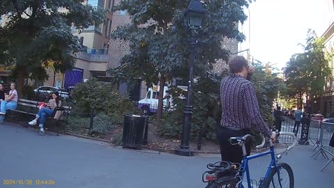 Washington Square Park, 1244 pm, left edge, observe the spy couple next to the bike