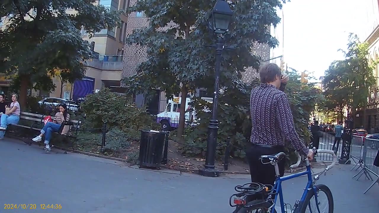 Washington Square Park, 1244 pm, left edge, observe the spy couple next to the bike