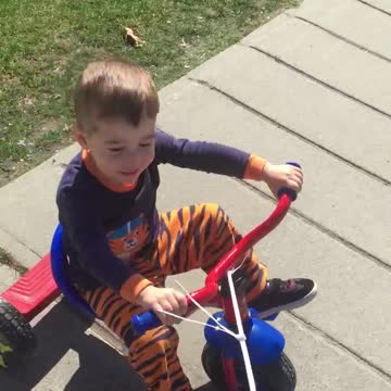 My grand son riding tricycle around my neighbourhood