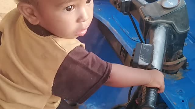 A cute kid imitating the sound of a tuk-tuk.