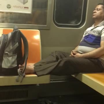 Man sits with no shoes on on subway