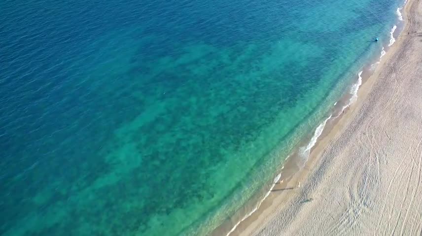 Flying over a peaceful and sunny beach