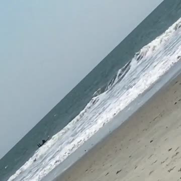 Guy on white surfboard gets blown over by wind