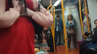 Red dress doll person dancing to music subway