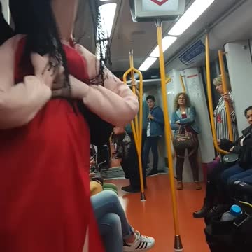 Red dress doll person dancing to music subway