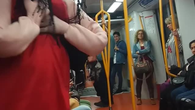 Red dress doll person dancing to music subway