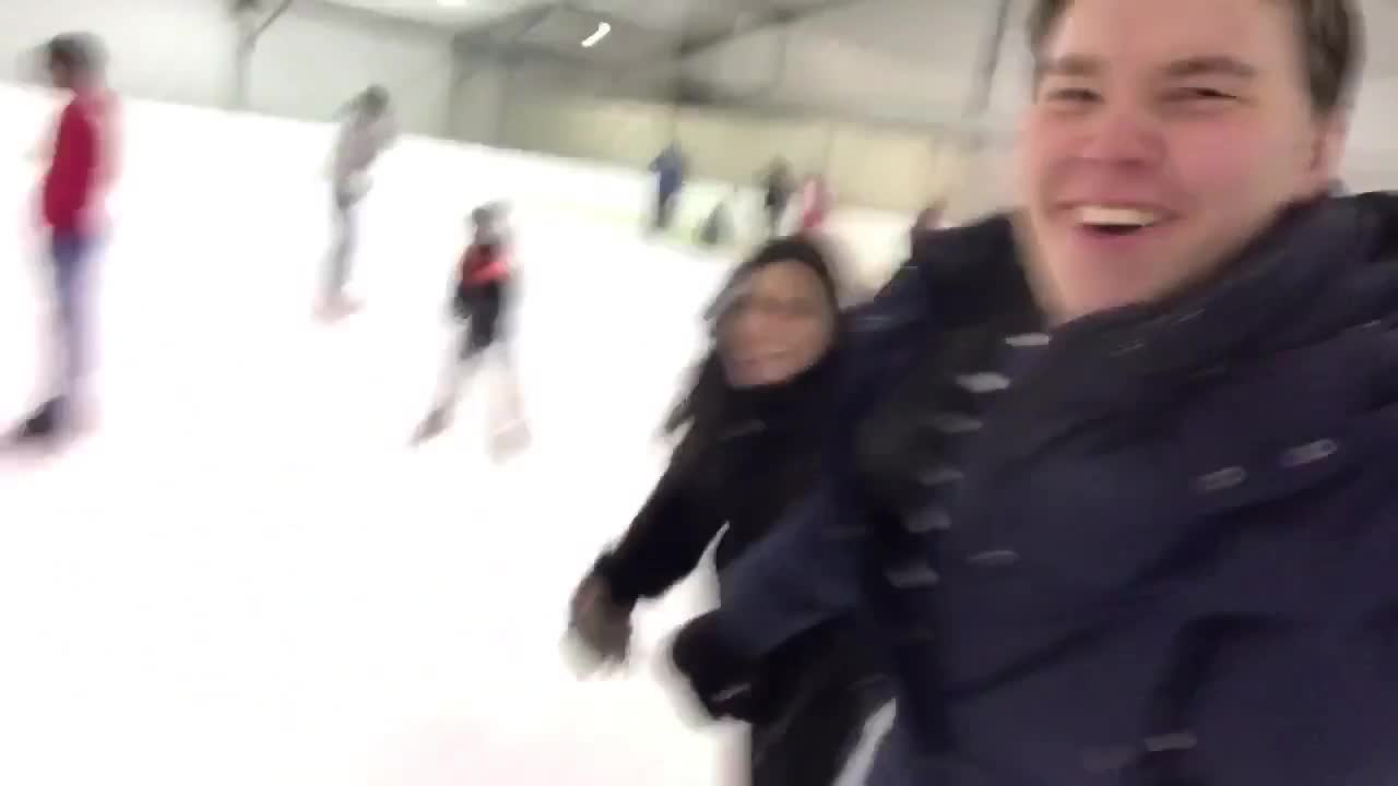 Couple ice skating girl falls