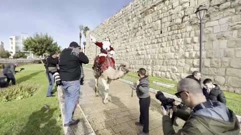 Papá Noel recorre la Ciudad Vieja de Jerusalén a lomos de un camello