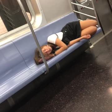 Girl with glasses asleep on her pink purse